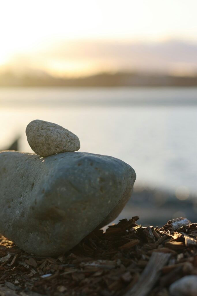 two-stones-stacked-on-a-beach-at-sunset-wbhrlxfb22q