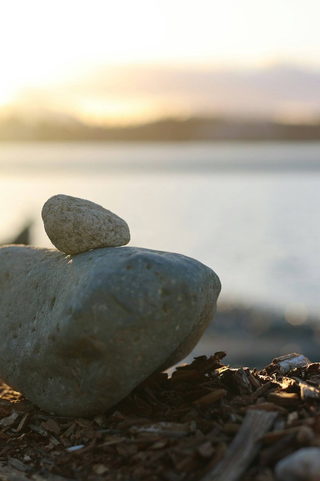 two-stones-stacked-on-a-beach-at-sunset-wbhrlxfb22q